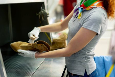 Photo for Professional dry cleaning young girl removes a stain from her shoes the suede is in perfect condition - Royalty Free Image