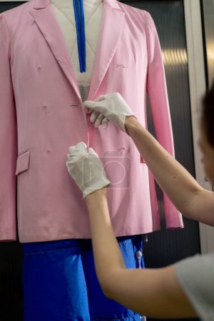 Photo for Close up professional dry cleaner a young girl takes a suit out of the dryer for finishing by hand press - Royalty Free Image