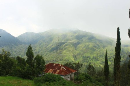 A house with misty mountains in the background