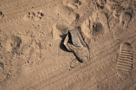 Foto de Huellas en la arena con un zapato desgastado a su lado. Foto de alta calidad - Imagen libre de derechos