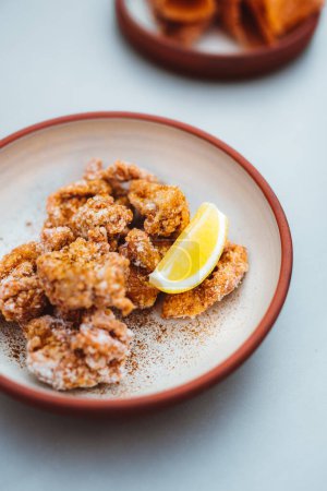 Téléchargez les photos : Chicken nuggets in a bowl with lemon piece at the restaurant table. Fast food and snacks concept - en image libre de droit