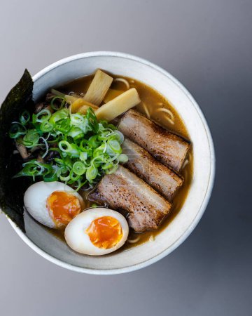 Téléchargez les photos : Soupe de nouilles asiatiques Miso Ramen avec bœuf, œuf et chou pak choi sur fond noir, vue sur le dessus. Photo de haute qualité - en image libre de droit