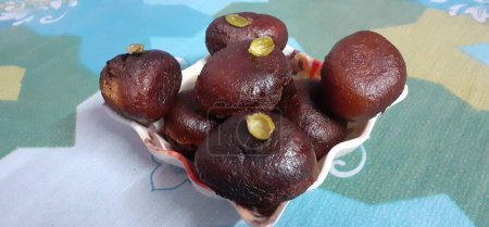 Photo for Kala Jamun is an Very very popular Indian Sweet Dish made from milk solids. This sweet item dipped fried in Sugar syrup with cardamom and saffron. - Royalty Free Image