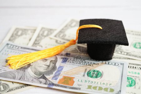 Foto de Graduation gap hat on US dollar banknotes money, Education study fee learning teach concept. - Imagen libre de derechos