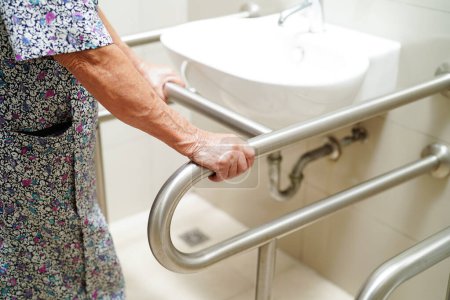 Téléchargez les photos : Vieille femme âgée asiatique utilisation patient rail de soutien de toilette dans la salle de bain, barre d'appui de sécurité main courante, sécurité dans l'hôpital de soins infirmiers. - en image libre de droit