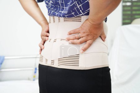 Foto de Asiático senior usando elástico soporte cinturón puede ayudar a reducir el dolor de espalda. - Imagen libre de derechos