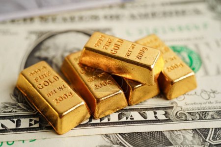 Téléchargez les photos : Lingots d'or sur l'argent des billets en dollars américains, finance trading investissement business currency concept. - en image libre de droit