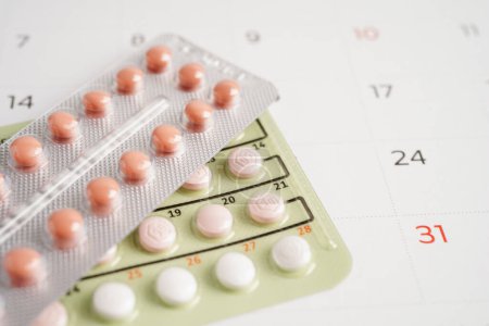 Foto de Píldoras anticonceptivas para las mujeres en el calendario, día de la ovulación. - Imagen libre de derechos
