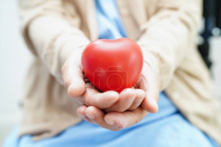 Photo for Asian elder senior woman patient holding red heart in hospital. - Royalty Free Image