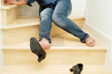 Téléchargez les photos : Asiatique femme d'affaires douleur cheville, pied avec crampe de jambe et tomber dans les escaliers parce que les surfaces glissantes au bureau. - en image libre de droit