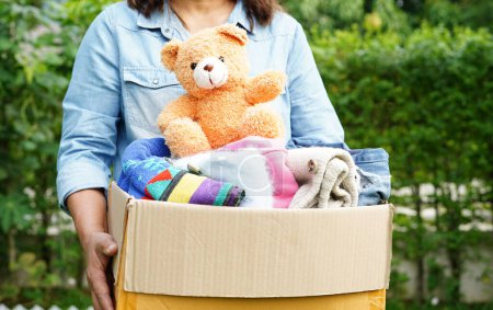 Téléchargez les photos : Recueillir bénévolement tissu et poupée dans une boîte en carton pour faire un don. - en image libre de droit