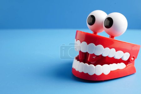 Dents rouges drôles avec un modèle de prothèse ophtalmique pour les soins dentaires.