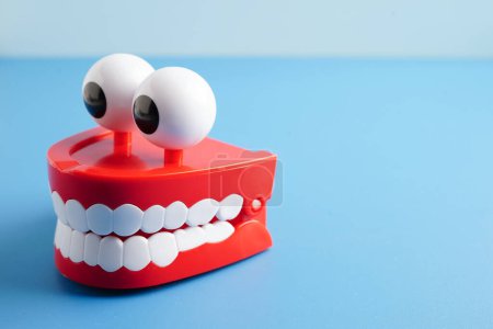 Funny red teeth with eye toy denture model for dental health care.