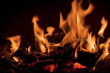 Foto de Llamas de fuego con troncos de leña dentro de una chimenea fotos de otoño fotos románticas de fuego - Imagen libre de derechos