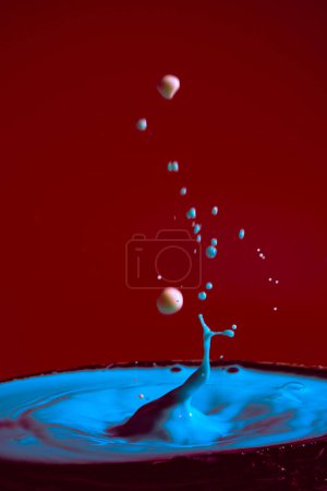 Photo for Collision of moving water drops of blue color on a purple red background forming figures and waves when falling and colliding with each other photography and high resolution images relaxation photography - Royalty Free Image