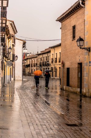 Foto de People with umbrellas in an urban landscape in the streets wet by the rain urban photography - Imagen libre de derechos