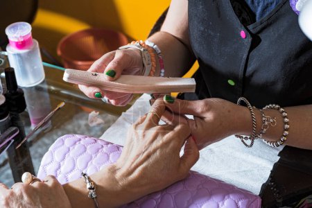Foto de Process of a manicure in the beauty salon sanding nails photography of care and beauty - Imagen libre de derechos
