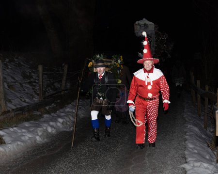 Foto de A clown and a bell-bearer lead a perchten procession in the Austrian Gastein Valley. High quality photo - Imagen libre de derechos