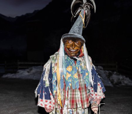 Foto de Witch with a doll in her hands - the character of the perch procession in the Austrian Gastein Valley, Austria. High quality photo - Imagen libre de derechos