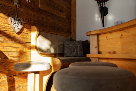 Téléchargez les photos : Coin canapé avec un mur en bois d'un restaurant alpin, illuminé par le soleil du matin, Autriche. Photo de haute qualité - en image libre de droit