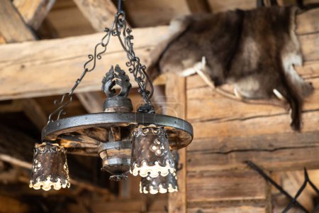 Téléchargez les photos : Lampe ajourée en métal sur le fond de l'intérieur en bois d'un restaurant alpin dans une station de ski, Autriche. Photo de haute qualité - en image libre de droit