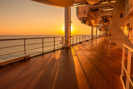 Promenade deck of a cruise ship in navigation with sunset.