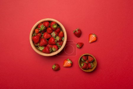 Foto de Bowl with fresh strawberries on color background, top view. - Imagen libre de derechos