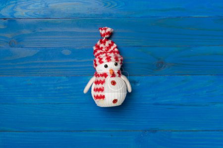 Foto de Pequeño muñeco de nieve de Navidad sobre fondo de madera, vista superior. - Imagen libre de derechos