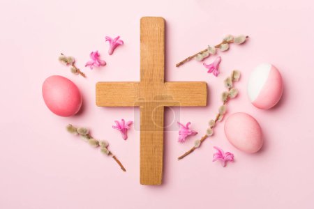 Photo for Pink Easter eggs with cross and palm leaves on color background, top view - Royalty Free Image