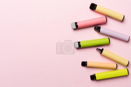 Foto de Disposable electronic cigarettes on color background, top view - Imagen libre de derechos