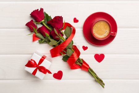 Téléchargez les photos : Tasse de café rouge avec des roses sur fond en bois, vue sur le dessus - en image libre de droit