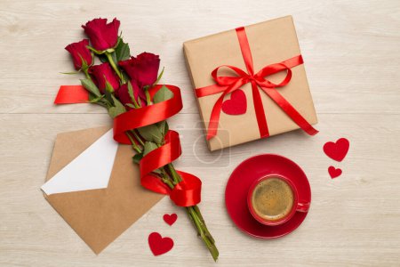 Téléchargez les photos : Tasse de café rouge avec des roses sur fond en bois, vue sur le dessus - en image libre de droit
