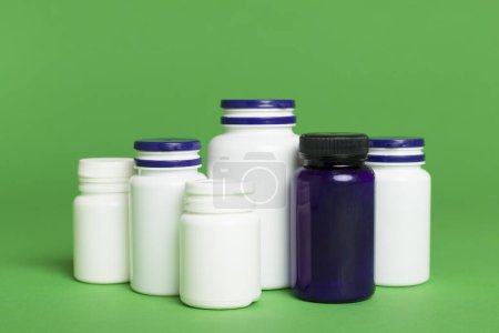 Foto de Frascos de plástico para vitaminas sobre fondo de color - Imagen libre de derechos