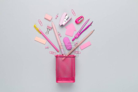 Foto de Porta lápices rosa con papelería escolar en color backgroung, vista superior - Imagen libre de derechos