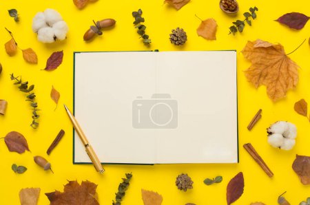 Foto de Hojas de otoño con cuaderno sobre fondo de color, vista superior - Imagen libre de derechos