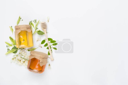 Foto de Frascos con diferentes tipos de miel en el fondo de color, vista superior - Imagen libre de derechos