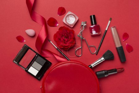 Téléchargez les photos : Sac cosmétique avec des produits de maquillage et des fleurs sur fond de couleur - en image libre de droit