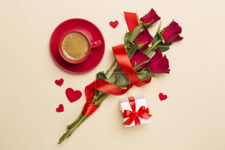 Téléchargez les photos : Red cup of coffee with roses on color background, top view - en image libre de droit