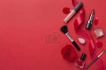 Téléchargez les photos : Pose plate avec des produits de maquillage et des outils avec des fleurs sur fond de couleur - en image libre de droit