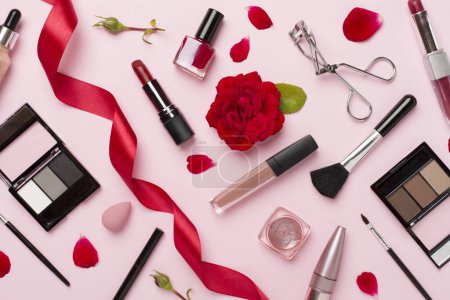 Téléchargez les photos : Pose plate avec des produits de maquillage et des outils avec des fleurs sur fond de couleur - en image libre de droit