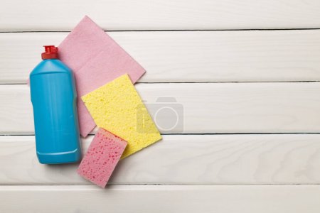 Foto de Bottle with dishwashing detergent and sponges on wooden background, top view. - Imagen libre de derechos