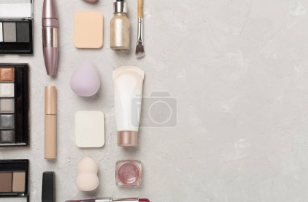 Téléchargez les photos : Pose plate avec des produits de maquillage et des outils sur fond de béton - en image libre de droit