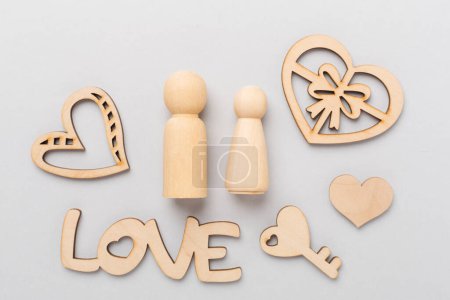 Téléchargez les photos : Couple en bois amoureux sur fond de couleur, vue de dessus. Composition créative Saint-Valentin - en image libre de droit
