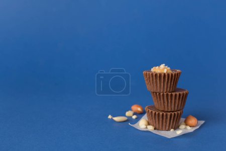 Foto de Sabrosas tazas de mantequilla de cacahuete de chocolate sobre fondo de color - Imagen libre de derechos