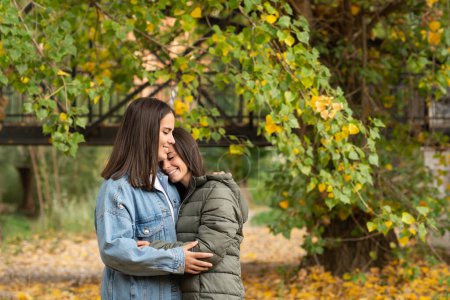 Foto de Retrato de pareja lesbiana abrazándose en un parque en un bonito día de otoño. - Imagen libre de derechos