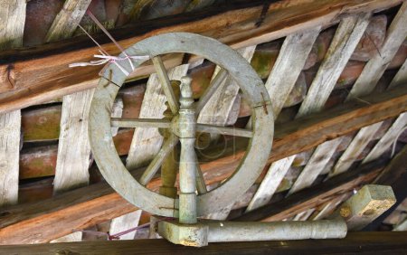 Téléchargez les photos : Broche en bois antique accrochée sous le toit d'une planche en bois - en image libre de droit