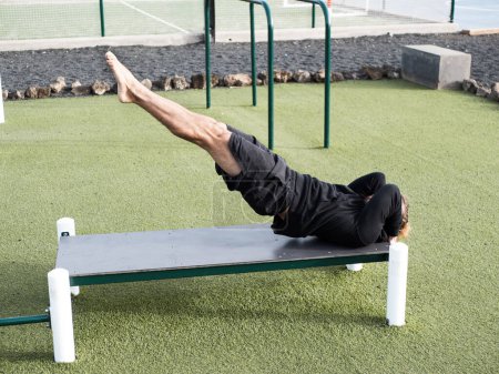 Photo for Athlete doing dragon flag abs exercise outdoor at the calisthenics park - Royalty Free Image