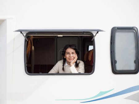 Téléchargez les photos : Hispanique 40s femme à la fenêtre du camping-car - en image libre de droit