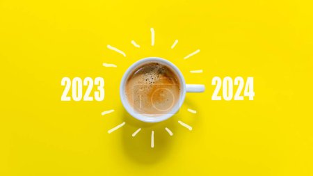 Photo for Happy new year and Merry Christmas 2024. Cup of coffee change and download 2023 to 2024 on yellow background. Start up and New Year Concept. Copy space - Royalty Free Image