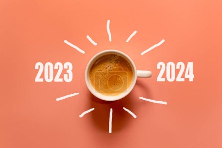 Frohes neues Jahr und frohe Weihnachten 2024. Tasse Kaffee ändern und herunterladen 2023 bis 2024 auf orangefarbenem Hintergrund. Gründungs- und Neujahrskonzept. Kopierraum 